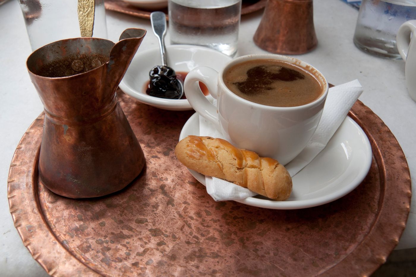 Greek coffee with a koulouraki cookie on a copper tray